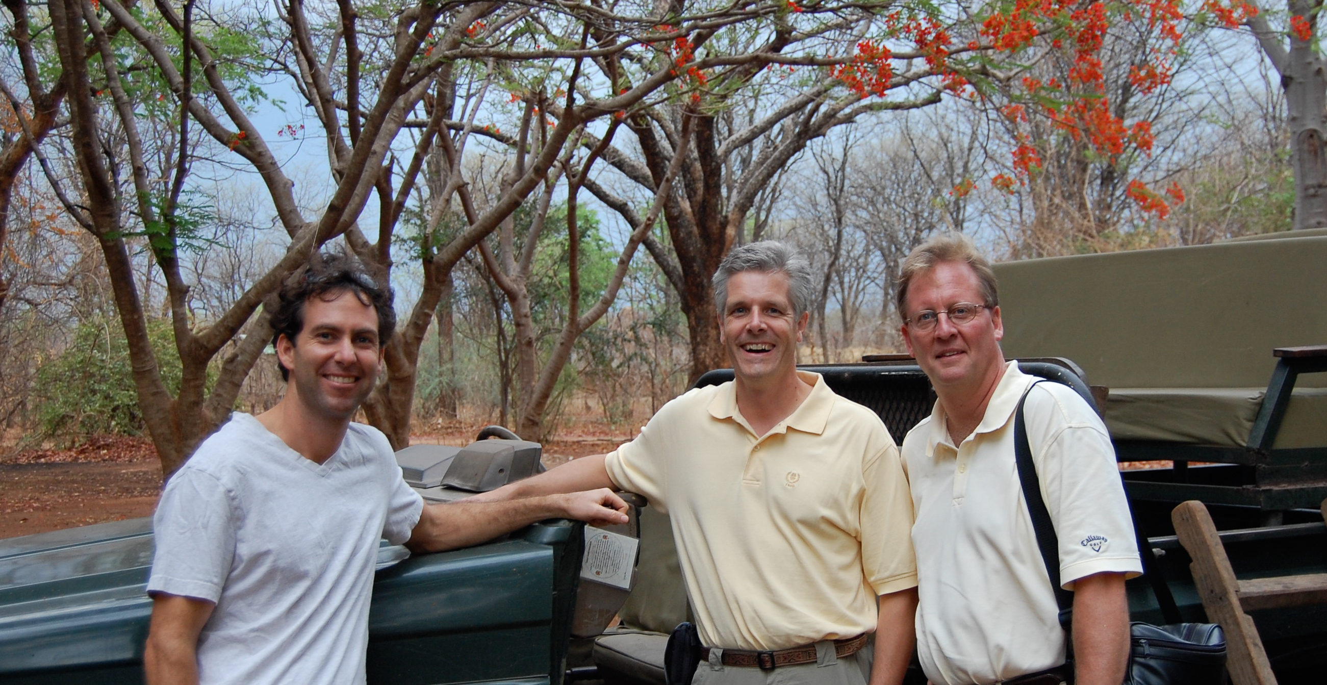 Original PFS volunteers and founders standing in front of a car.